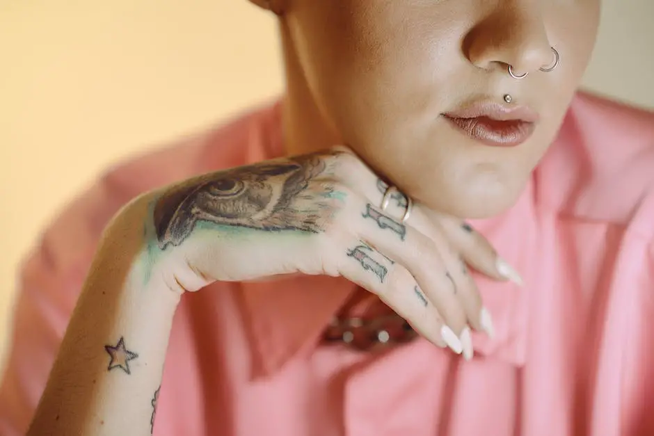 woman half face with septum piercing and nose ring. hand under the chin with tattoos